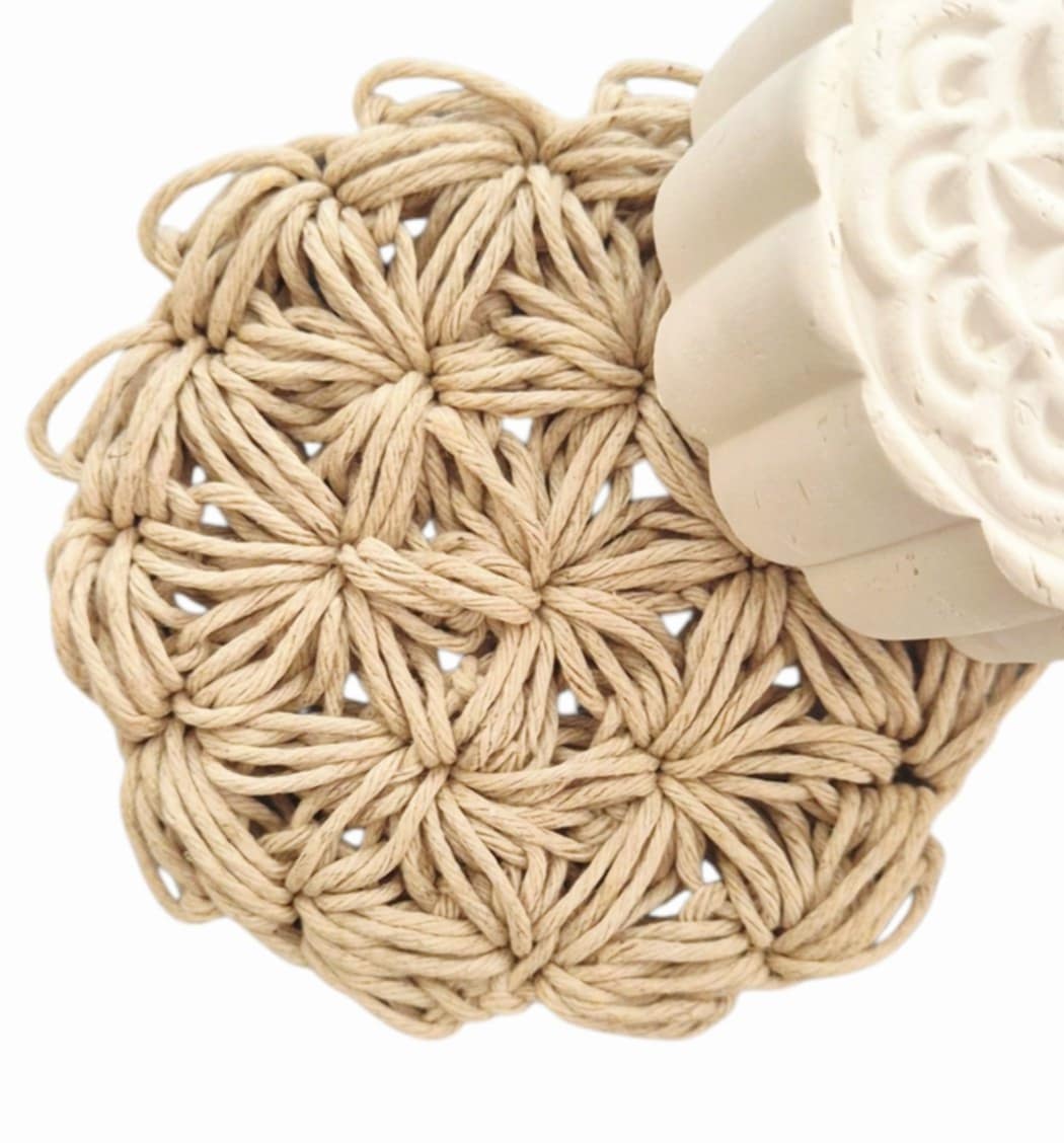 Crochet hemp face scrubby with textured white face clay on a white background