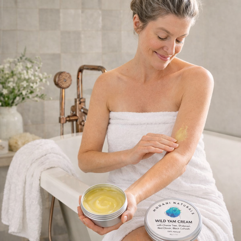 Woman applying Wild Yam Cream to her arm in a bathroom setting