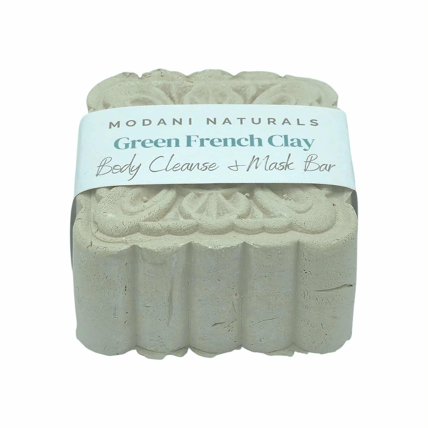 Green French Clay body cleanse mask bar with intricate floral pattern by Modani Naturals with label on a white background.