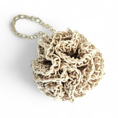 Beige hemp face cleansing pouf with strap on a white background