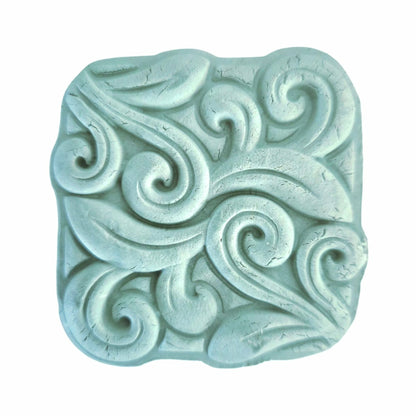 Textured blue clay stone face mask with swirling patterns on a white background