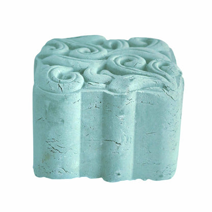 Textured blue clay face mask stone with swirling patterns on a white background