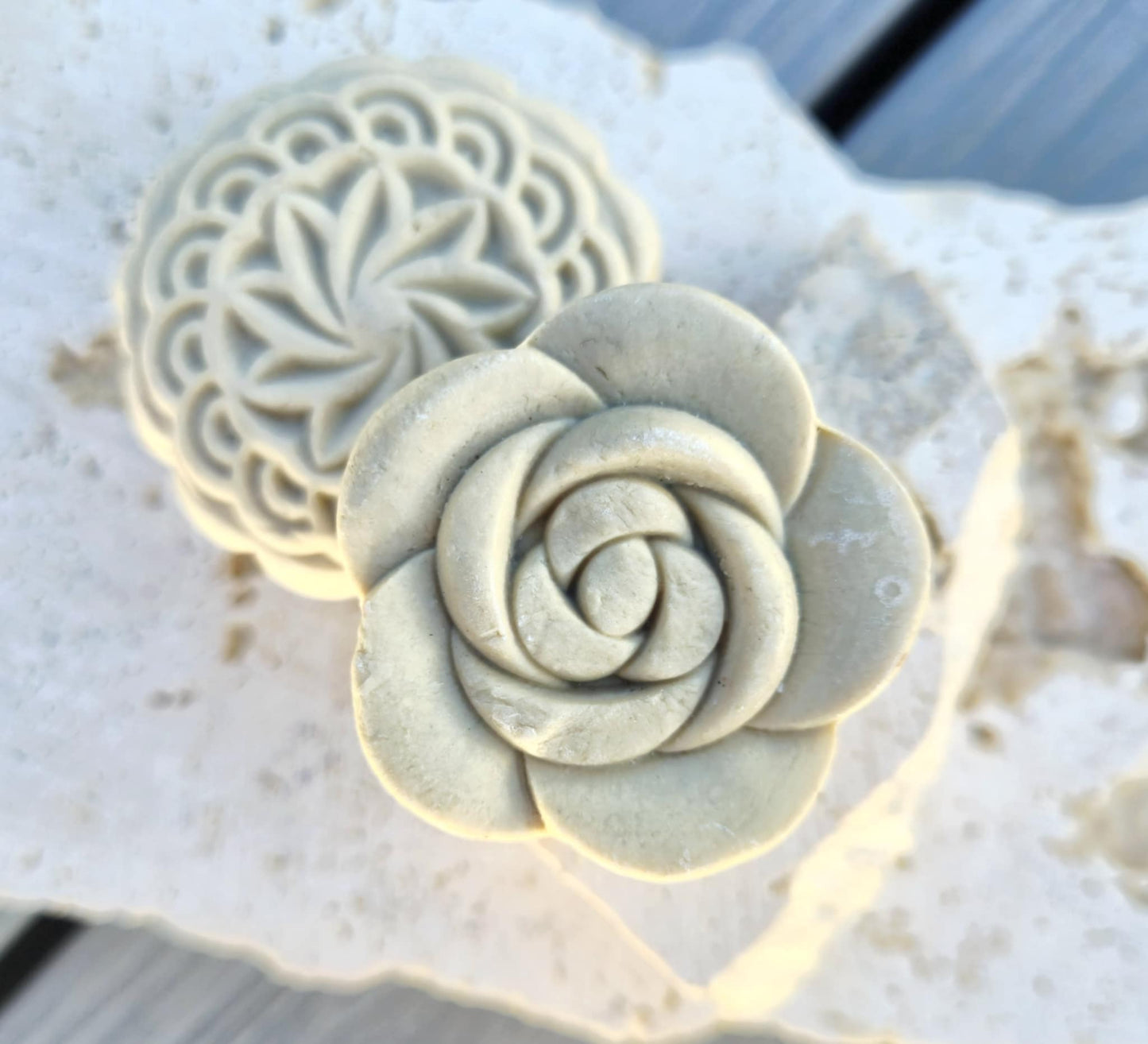 Decorative solid shampoo bar with rose floral designs on textured surface