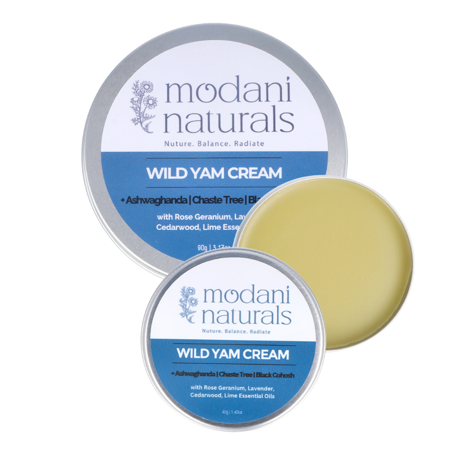 Two round metal tins of Modani Naturals Wild Yam Cream are shown on a white background, with one tin open to reveal a pale yellow balm and the other closed.
